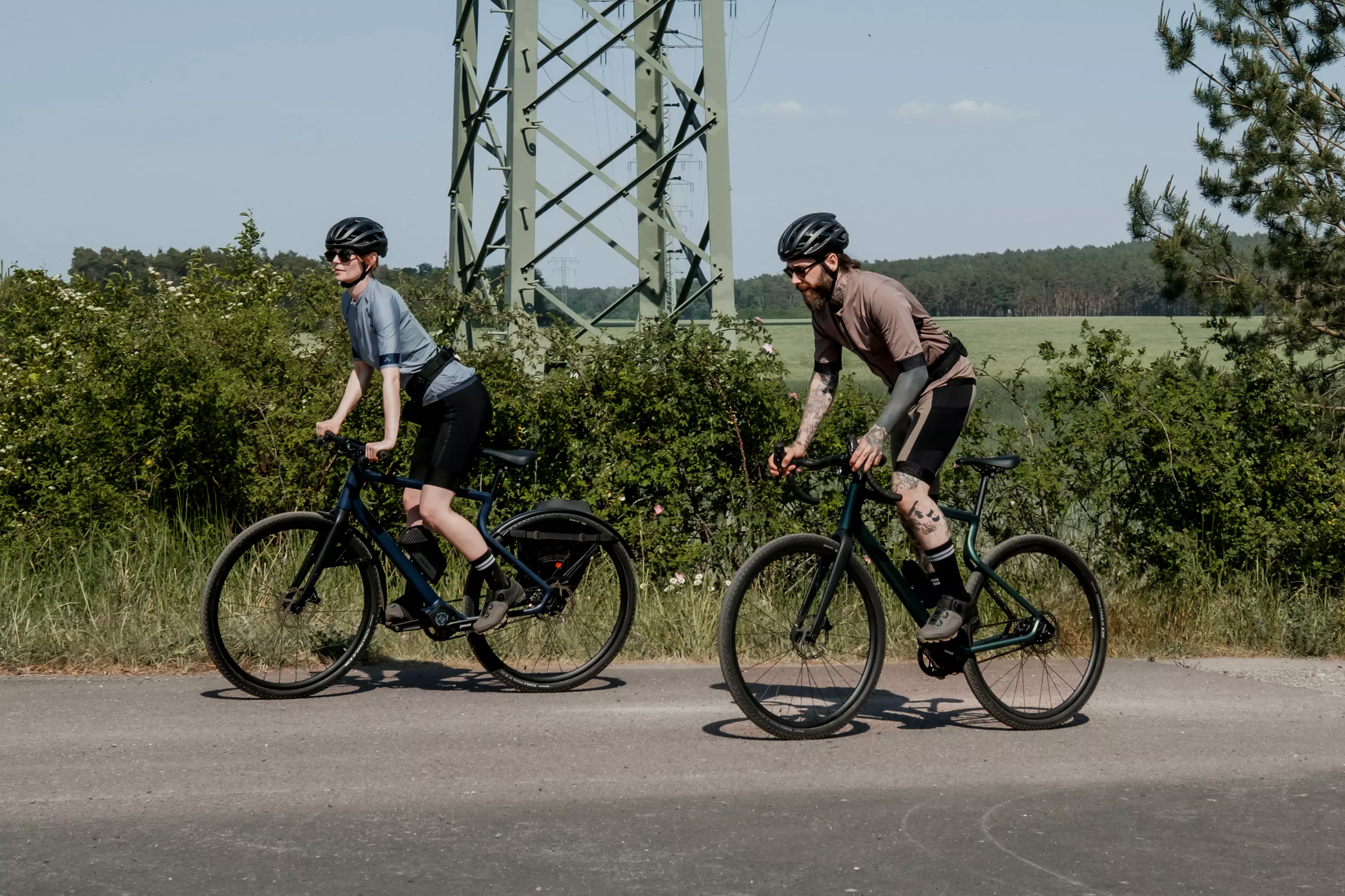 Zwei Gravler fahren jeweils mit dem Gravel E-Bike Waldwiesel durch die Natur