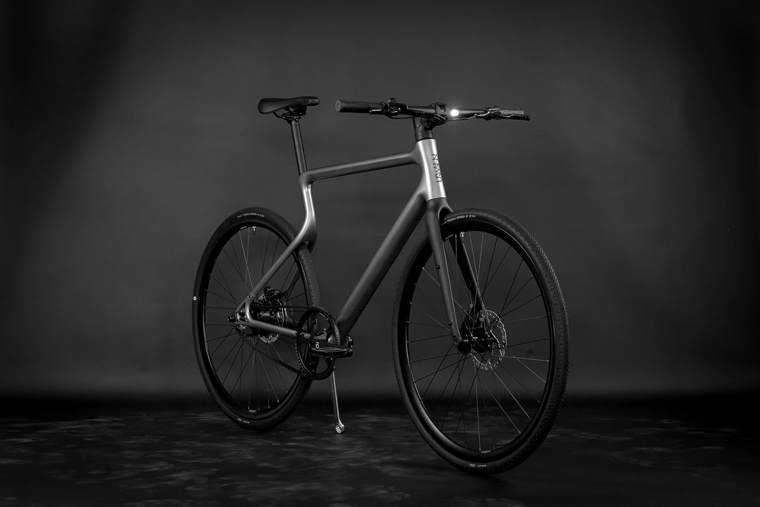 E-Bike Stadtfuchs in Vernickelung steht diagonal vor einem schwarzen Studiohintergrund